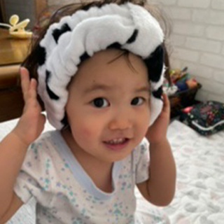 ママのヘアバンドをかぶって真似っこする2歳の娘。