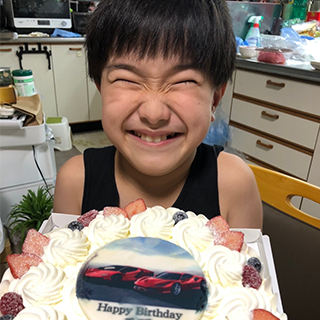 大好きなスポーツカーのケーキに喜びの顔全開!