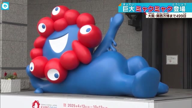 寝そべったミャクミャクの巨大モニュメント 大阪市役所前に設置